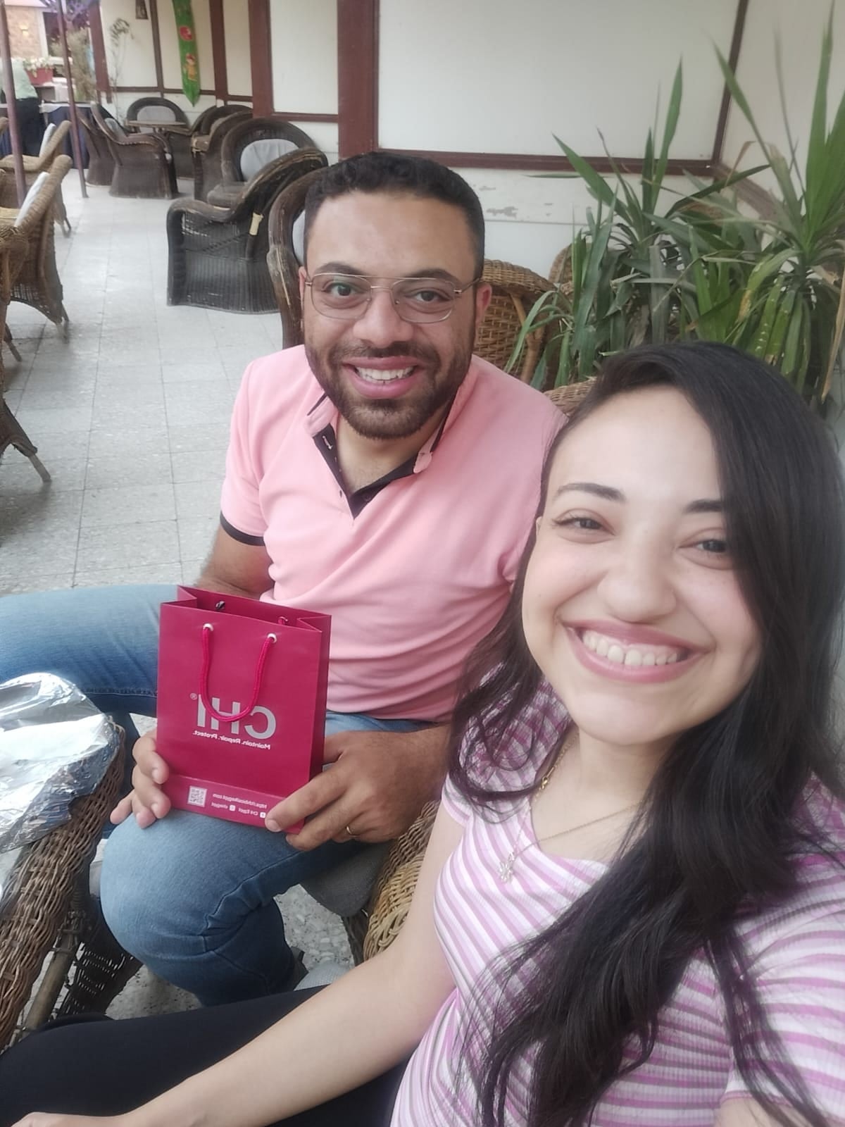 John holding a gift bag while Nada smiles at the camera