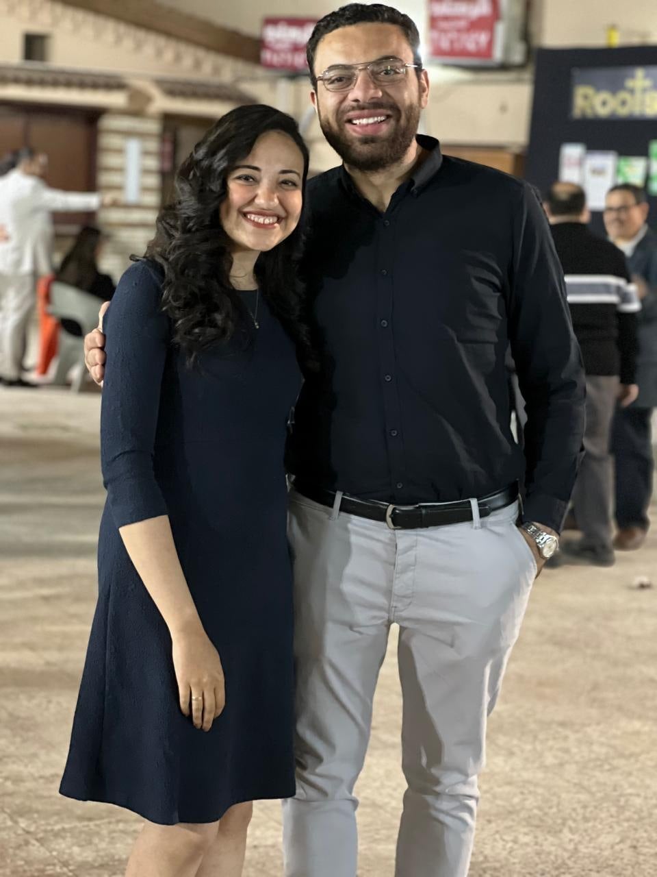 Nada and John standing together outside the church at night
